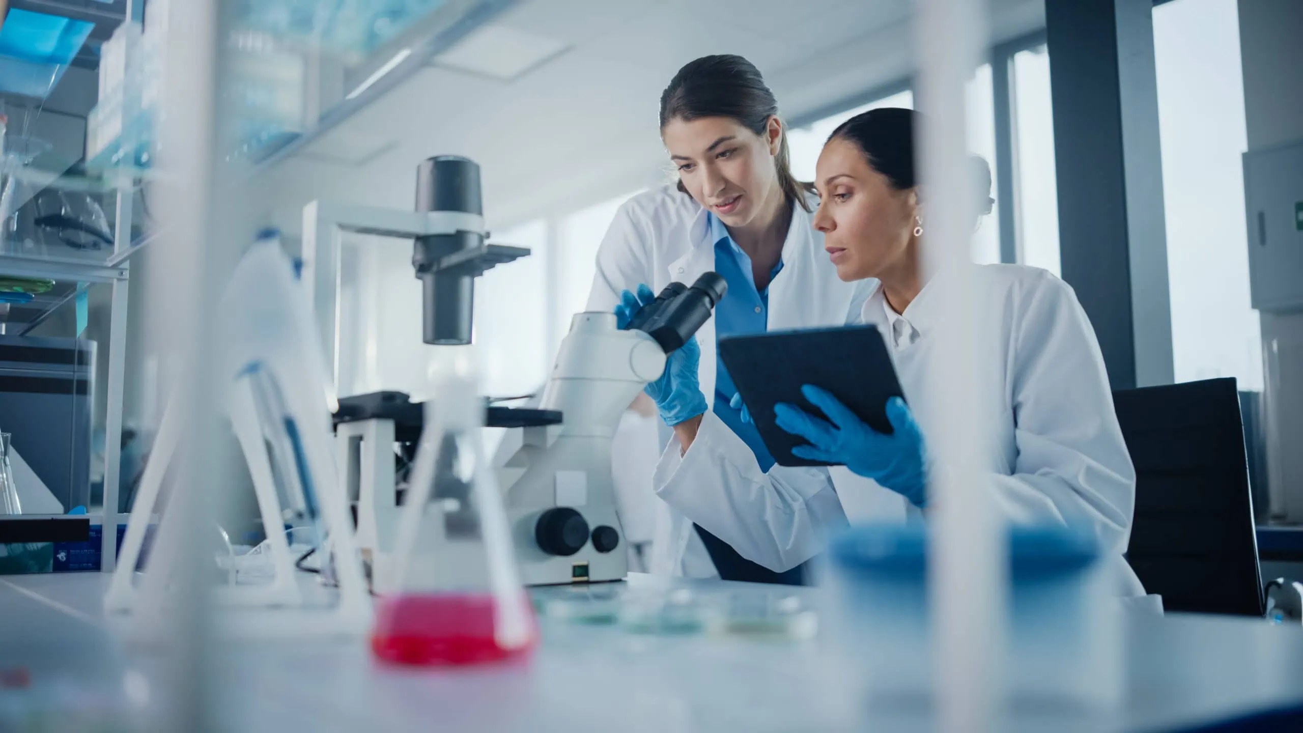 Modern,medical,research,laboratory:,two,female,scientists,working,,using,digital